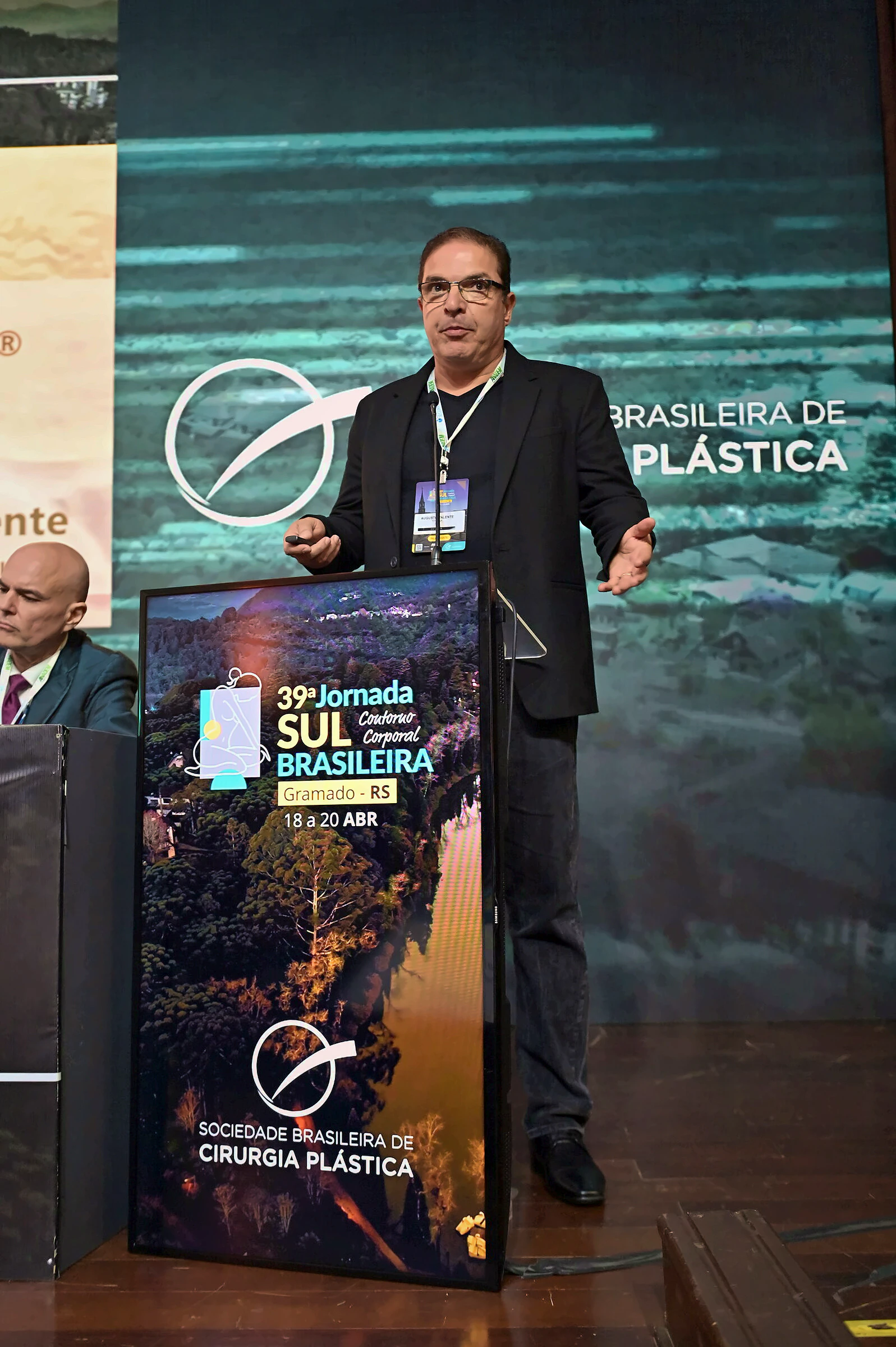 Dr. Augusto Valente interagindo com o público durante apresentação na Jornada Sul-Brasileira de Cirurgia Plástica, em Gramado